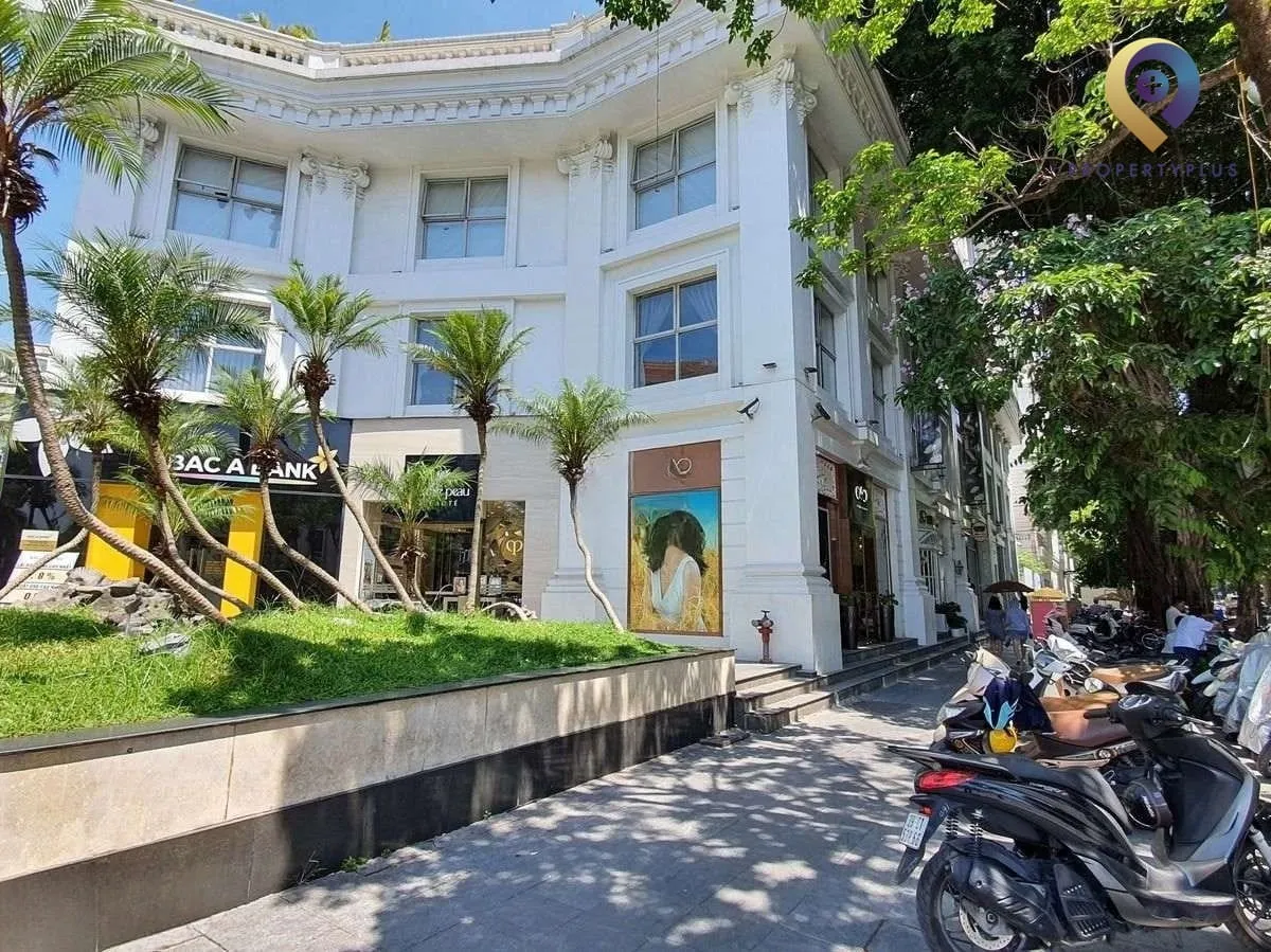 Khu vực sảnh ngoài tòa nhà Opera Business Centre với hàng cây xanh và lối vào.
